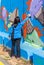 A young woman paints a picture with a color spray on a concrete security fence on the border between Israel and Lebanon.