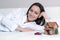 Young woman in pajamas lying on a white sofa in a room in front of a Wendy house and a car, and dreams of a bright future.