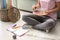 Young woman with palette and paintbrush sitting on floor at home