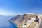 Young Woman on Parapet in Front of Panoramic View of Thira City in Santorini Island in Greece