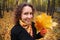 Young woman in park in autumn with yellow leaves