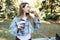 Young woman in park at lunchtime eating sandwich and drinking coffee