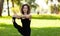 Young woman in park practicing yoga. Standing Hand to Toe Preparation