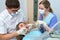 Young woman patient getting dental treatment at dental office, Dentist and assistant during teamwork.