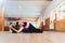 A young woman performing yoga-asanas in the hall. Eka pada shirshasana. Pavirittu Jana Shirshasana.