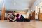 A young woman performing yoga-asanas in the hall. Eka pada shirshasana. Pavirittu Jana Shirshasana.