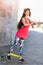 Young woman performs exercises with fitness rubber bands on the embankment on a warm sunny morning