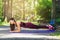 Young woman performs a plank exercise with fitness straps in the fresh air