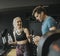 Young woman and personal trainer rest in the gym after workout