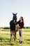 Young woman petting black horse