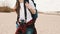 Young woman photographer and adventurer walking along the sandy beach in slow motion.