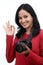 Young woman photographer making Ok sign
