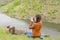 Young woman photographing a man on a cliff top