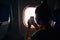 Young woman photographing view from the aircraft window during the flight in the airplane