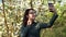 A young woman photographs herself against the backdrop of an apple tree. Girl in the blooming garden.