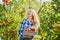 Young woman picking apples in garden