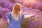 Young woman picking lavender flowers at sunset.