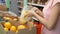 Young woman picking an oranges from box at supermarket