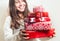 Young woman with pile of nicely packed christmas gifts