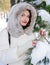 Young woman beside pine tree with snowbound branches