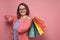 Young woman in pink clothes after shopping being excited