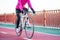 Young Woman in Pink Jacket Riding Road Bicycle on the Bridge Bike Line in the Cold Sunny Autumn Day. Healthy Lifestyle.