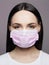 Young Woman in pink Mask. medical masked beautiful girl