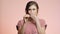 Young woman on pink studio background young woman in anticipation looks at disposable medical pregnancy test but frustrated, girl