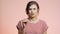 Young woman on pink studio background young woman in anticipation looks at disposable medical pregnancy test but frustrated, girl