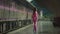 A young woman in a pink suit with a suitcase missed her train