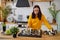 Young woman playing chess on kitchen table. Female plays in logical board game with herself in kitchen.