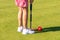 A young woman is playing croquet on a lawn