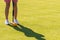 A young woman is playing croquet on a lawn