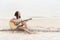 Young woman playing guitar on the beach. Musician lifestyle. Travel concept