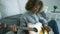 Young woman playing guitar at home