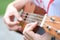 A young woman playing string music ukulele in the summer