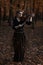 Young woman playing violin in the fall park