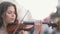 Young woman playing a violin at the pedestrian street