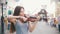 Young woman playing a violin at the pedestrian street