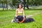 Young woman plays with briard on glade in park.