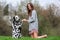 Young woman plays with an Dalmatian dog outdoors