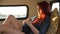 Young woman plays the reclining ukulele on the couch in the trailer