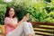 Young woman plays a small kalimba on a bench in her spare time in the home garden.