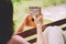 Young woman plays a small kalimba on a garden bench at home.