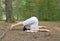 Young woman in plough pose in the forest