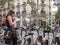 Young woman in polka dot dress reads map by Velib bicycles, Paris, France