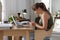 Young woman with poor posture using smartphone at table indoors