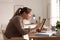 Young woman with poor posture using tablet at table