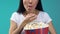 Young woman with popcorn attentively watching TV show, overeating, junk food