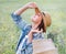 Young Woman portrait closed the eyes and enjoying the sun rays. She dressed a jeans jacket, straw hat and light summer dress. She